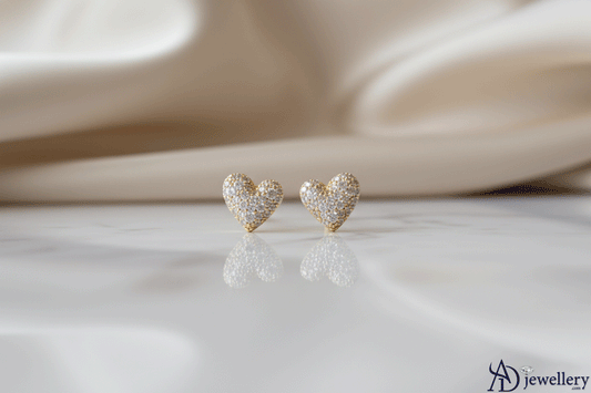 Micro-Pave Love Studs featuring delicate heart-shaped gold earrings encrusted with sparkling micro-pavé stones, displayed on a soft, elegant background.